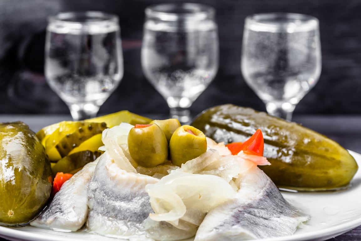 Traditional appetizer - herring, cucumber and vodka shots, polish cuisine