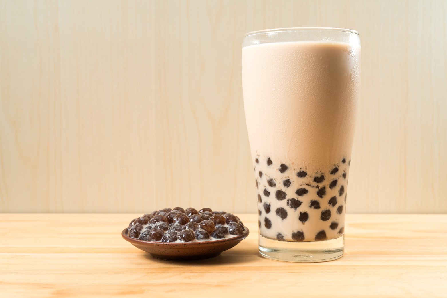 A Glass Cup of Pearl Milk Tea (Also Called Bubble Tea) and a Plate of Tapioca Ball on Wooden Background. Pearl Milk Tea Is the Most Representative Drink in Taiwan. Taiwan Food . with Copy Space.